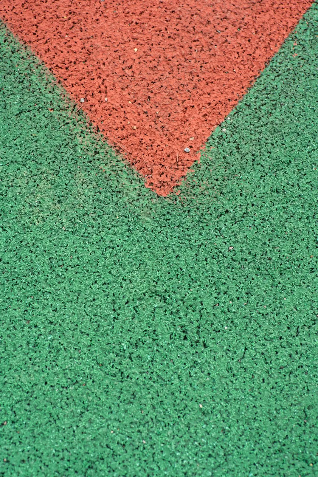 Close-up of red and green rubber crumb surfacing meeting at a seam